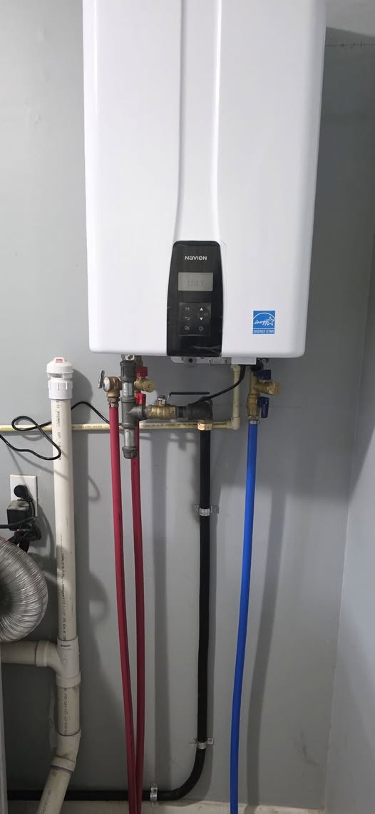 Interior Navien tankless water heater with connected water and gas lines
