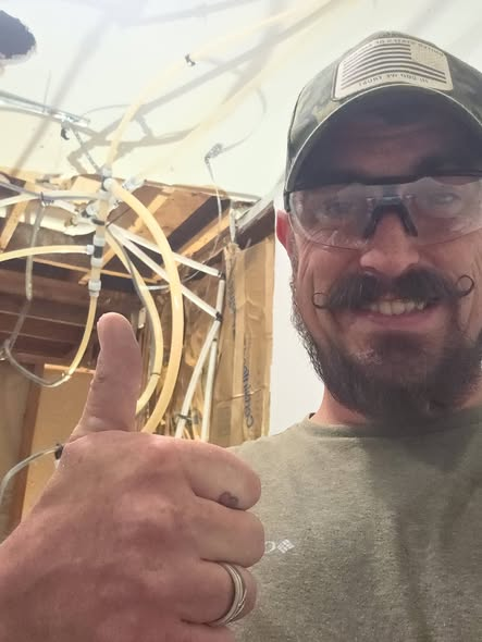 Plumbing technician beside newly installed water supply lines